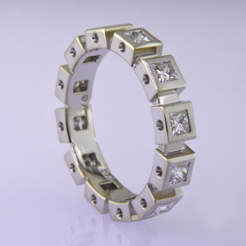 Modern and classic, this princess cut diamond anniversary ring will never go out of style. Wear it as a stacking or single ring, an anniversary ring, or a wedding ring. We can make it in any karat or color of gold, and platinum. This one is in 14 karat white gold, and has 1.23ct. total diamond weight of princess cut diamonds winding all the way around. For the girl who wants to have a little extra fun, pair it with these 3mm beveled black gem ceramic rings. It definitely makes the anniversary ring stand out even more. (Ceramic bands are sold seperately) Ring is a size 7.

This custom designed anniversary ring is individually crafted to be Perfectly You, and takes about 2 weeks to create. Call us for more information about how we can customize this design Just For You. Designed, and created in our studio by the artist Stuart J.

The gem ceramic rings are hypoallergenic, and environmentally friendly. Made with Gem Ceramique, this ring uses high tech zirconia ceramic, virtually as hard as sapphire. Ultra durable and stylish, versatile and unique. It even has a Lifetime "Peace of mind" warranty against breakage. 

Created by award winning jewelry artist Etienne Perret, and made in his studio in Camden, Maine.

This custom designed anniversary ring is individually crafted to be Perfectly You, and takes about 2 weeks to create. Call us for more information about how we can customize this design Just For You. Designed, and created in our studio by the artist Stuart J.