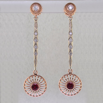 You will look spectacular and feel like a princess in these regal, sophisticated diamond and ruby earrings that dangle and dance. Hand crafted in beautiful 14 karat rose and white gold. At the top are two beautiful 1/5 carat ideal cut diamonds, with another .28ct of ideal cut diamonds sprinkled in the white gold bars, for a total of .68ct. Dangling on the bottom are interchangeable rose gold drops that each hold a beautiful 5mm Chatham® created rich red ruby. We can make the bottoms with any gemstone you like, to match any outfit in your wardrobe. These earrings measure 2 1/2 inches long and are designed and handcrafted by the artist Stuart J. Call us for more information about how we can customize this design Just For You. 
Chatham® Created Gemstones are grown in carefully controlled laboratory conditions. They are chemically and optically identical to their natural counterparts, yet cost much less. Because the environment in which they are grown is controlled, the imperfections often found in natural gemstones, are absent in Chatham® Created Gemstones. Because of this, and superior cutting, Chatham® gems exhibit the color and sparkle of the finest natural gems. Eco-friendly and conflict free, each one comes with a Certificate of Authenticity, and a Lifetime Warranty.