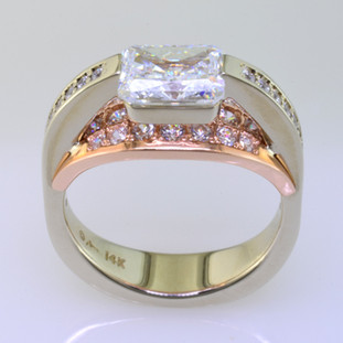 This contemporary diamond engagement ring will really make you feel special, and can be made in gold or platinum, or both. Feel modern, elegant, and cool when wearing this diamond engagement ring. Shown in 14 karat white and rose gold, with 73ct. of ideal round cut diamonds cascading down both sides and a 1.00ct. fancy radiant cut center (priced separately). This diamond engagement ring is great for professionals who work with their hands, because there are no prongs to catch. 

This custom designed diamond engagement ring is individually crafted, to be Perfectly You, and takes about 3-5 weeks to create. Call us for more information about how we can customize this design Just For You. Designed, and created in our studio by the artist Stuart J.