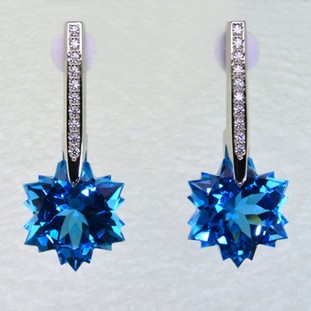 What's better than one sparkling snowflake? Two, of course. One for each ear. And you can turn up the heat, because these snowflakes won't melt. Exclusively ours, each blue topaz snowflake is custom cut just for us, in Canada, by master gem cutters who know what snowflakes look like. Each snowflake measures 12mm, and dangles from the bottom of 14 karat white gold icicle Piercettes®, glistening with .16ct. T.W. of ideal cut diamonds. These gorgeous earrings measure 1 inch long, and have posts with clutch backs. They are available with Colorless Topaz, Amethyst, and Citrine.  Other colors could take up to 8 weeks delivery, but ask anyway!

Designed and handmade by the artist Stuart J.

A Piercette® is a patented method of setting, with a gemstone that moves. The gem is set so that it swivels with every movement of the wearer, exhibiting extra sparkle.