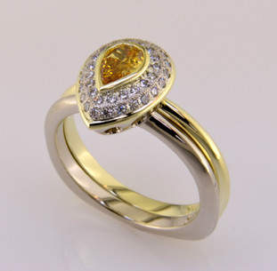 Here is a diamond halo engagement ring with a sophisticated flare. Custom designed with .20ct. T.W. of pavé set ideal cut diamonds makes this ring sparkle like crazy. A beautiful .28ct. Pear shaped natural color golden yellow diamond is the focal point of this double row pavé halo. It is set in a green gold bezel to accentuate its vivid color, and makes it look larger than it is. And not a single prong to worry about! This pavé diamond engagement ring feels smooth and is easy to wear. It is hand made in 14 karat white gold, with a 14 karat Green gold accent border around the diamonds. You will love the custom touches on this sweet engagement ring, like the beautiful open design on the underside. A matching wedding ring in 14 karat green gold is shown, and compliments the set perfectly. (Priced seperately) 

As with all of our designs, we will make this any way you like, with any gemstones you like.

Custom designed and hand crafted in our studio by the artist Stuart J.