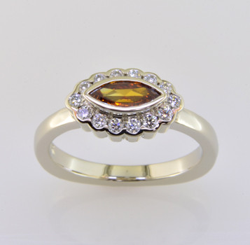 Born into our family on April 25th (with a Diamond Birthstone), and weighing in at a modest .52 carat total weight, this spectacular modern diamond halo engagement ring is set with a .29 carat natural color orangy yellow marquise diamond. We cradled it with .23 carat of colorless ideal cut diamonds, set in white gold with no prongs to worry about. Truly, our new baby will be loved by all. This one fits a size 6 finger, but we will happily make Ginger to fit your finger.

We made a matching set of twin wedding rings in 18 Karat yellow gold (shown), that compliments this engagement ring perfectly. They are priced seperately here Ginger Wedding Ring.

As with all of our designs, we will make this any way you like, with any gemstones you like, including yours.

Custom designed and hand crafted in our studio by the artist Stuart J. 