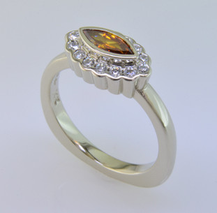 Born into our family on April 25th (with a Diamond Birthstone), and weighing in at a modest .52 carat total weight, this spectacular modern diamond halo engagement ring is set with a .29 carat natural color orangy yellow marquise diamond. We cradled it with .23 carat of colorless ideal cut diamonds, set in white gold with no prongs to worry about. Truly, our new baby will be loved by all. This one fits a size 6 finger, but we will happily make Ginger to fit your finger.

We made a matching set of twin wedding rings in 18 Karat yellow gold (shown), that compliments this engagement ring perfectly. They are priced seperately here Ginger Wedding Ring.

As with all of our designs, we will make this any way you like, with any gemstones you like, including yours.

Custom designed and hand crafted in our studio by the artist Stuart J. 