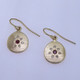 These sweet earrings shimmer when you wear them. Beautiful and rich 18 karat yellow gold medallion drops sprinkled with .11ct. of ideal cut diamonds set in a starburst pattern, with a glowing ruby in the center, hanging from wires. 12mm long.  

Designed and created in our studio by the artist Stuart J.