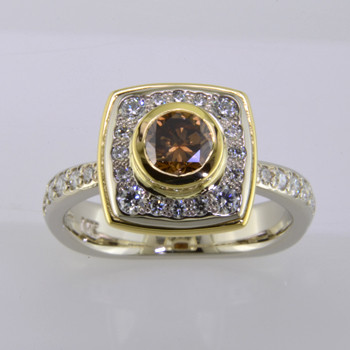 Here is a diamond halo engagement ring with a sophisticated flare. Custom designed with .45. T.W. of pavé set ideal cut diamonds makes this ring sparkle like crazy! A beautiful .57ct. round natural cognac color diamond is the focal point of this uniquely styled pavé halo diamond ring. It is set in an 18 karat yellow gold bezel to accentuate its vivid color, and also happens to make it look more like a one carat diamond! And not a single prong to worry about! This pavé diamond engagement ring feels smooth and is easy to wear. It is hand made in 14 karat white gold, with an 18 karat yellow gold border to beautifully frame the diamond halo. You will love the custom touches on this sweet engagement ring, like the beautiful open design on the underside. 
As with all of our designs, we will make this any way you like, with any gemstones you like.

Custom designed and hand crafted in our studio by the artist Stuart J.