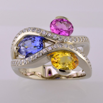 You will feel special with this very special gemstone ring on your finger. This unique, custom designed diamond and natural color sapphire ring has a display of color to rival nature! Yummy Blue, Yellow, and Pink oval, natural color sapphires, intertwined with .45 carat total weight of sparkling ideal cut diamonds. All meticulously set in 14 karat white gold. This diamond and sapphire gemstone ring will warm your heart, and make you smile every day! :) The finger size is 7, and can be sized up or down about 2 two sizes, plus or minus. 
This is a special, one of a kind piece.

Designed and created in our studio by the artist Stuart J.