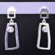 Fun, and funky earrings for the adventurous girl. Sterling silver dangles with rectangular shapes, bezel set with 2 colorless topaz gemstones resting on posts. Measures 1 inch long, and created in studio by french jeweler Sean Hill.