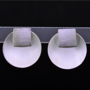 Fun for everyday, these earrings will be your go-to accessory. Modern soft circles with soft square tops in Sterling Silver, hanging from posts. Even better, remove the square tops and wear them as studs. You have two pairs for the price of one. Measure 3/4 inch long and 3/4 inches wide.

Handmade in Istanbul, Turkey.