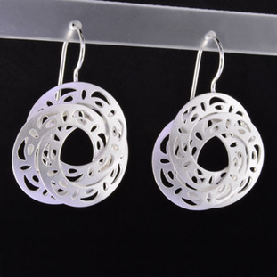 Playful and bright, these triple circle open filagree dangle earrings are a delight to wear and they will make you smile. Crafted in Sterling Silver with a floral pattern, hanging on wires, and measuring 1 3/4 inches long. 

Handmade in Istanbul, Turkey.