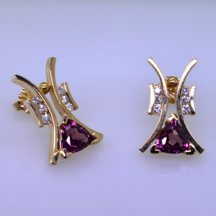 Striking, modern diamond earrings in 14 karat yellow gold with .18ct. T.W. of ideal cut diamonds, and 1.73ct. of rhodolite garnet trillian gemstones with posts.  These elegant diamond earrings measure 3/4". 

Designed, and created in our studio by the artist Stuart J.