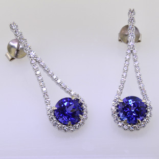 Sparkly, elegant, and sensual only begin to describe these Diamond and tanzanite gemstone earrings. Handcrafted in 14 karat White Gold with  .88cts. of fine Ideal cut Diamonds and 2 perfectly matched, super fine, rich blue tanzanites totaling 3.04ct.. Need we say more? Earrings measure 1 1/4 inches long, and hang on posts. 

Designed and handmade by the artist Stuart J.