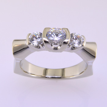 Beautiful, modern 3 stone anniversary ring that is simply elegant. 14 karat white gold, with .50ct. ideal cut round center, and 2 side ideal cut diamonds making this diamond ring weighing 1.00ct. Call us for more information about how we can customize this design Just For You. Designed, and created in our studio by the artist Stuart J.