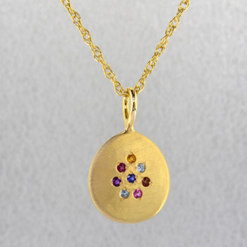 This sweet pendant shimmers when you wear it. Beautiful 14 karat yellow gold medallion sprinkled with aquamarine,ruby,garnet,amethyst,pink tourmaline, and blue zircon gemstones set in a starburst pattern, with a blue sapphire in the center, hanging on a 1.3mm rope  chain. 18" long.  

Wear it as a birthstone pendant too, and customize it just for you.  Call for prices on your special birthstones. Special orders will take 2-3 weeks

Designed and created in our studio by the artist Stuart J.