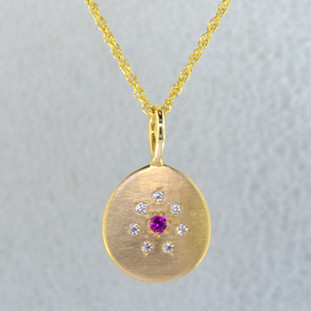 This sweet pendant has a special, hand applied finish that shimmers when you wear it. Beautiful and rich 14 karat yellow gold drop, sprinkled with .06 carat total weight of ideal cut diamonds, with a glowing pink sapphire gemstone in the center. Comes with an eighteen inch, 14 karat yellow gold rope chain. Pendant measures 5/8 inches long.  

Designed and created in our studio by the artist Stuart J.