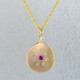 This sweet pendant has a special, hand applied finish that shimmers when you wear it. Beautiful and rich 14 karat yellow gold drop, sprinkled with .06 carat total weight of ideal cut diamonds, with a glowing pink sapphire gemstone in the center. Comes with an eighteen inch, 14 karat yellow gold rope chain. Pendant measures 5/8 inches long.  

Designed and created in our studio by the artist Stuart J.