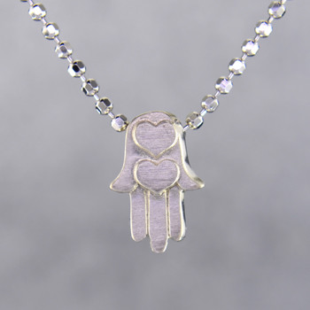 What's your story? Begin with this Little Faith Hamsa Hand, solid Sterling Silver charm. Wear it alone, with other charms, or layered with other necklaces. Comes with a sterling silver ball chain, 16 inches long. The charm measures 1/4 inch long. Too cute!

Signified by a feminine sensibility and optimistic charm, Alex Woo's Little Icon Collections reinvent familiar symbols from the world around us into fresh and expressive designs.

Designed and handcrafted by Alex Woo in New York City.