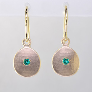 These sweet gemstone earrings shimmer when you wear them. Beautiful in rich 14 Karat yellow gold, these medallions with chatham created emerald gemstones in the center( 2mm), hanging from 14 Karat yellow gold wires.  Earrings measure 3/4 inch long. Available in other colors. Please call for pricing.
Designed and created in our studio by the artist Stuart J.

Chatham Gemstones are also available in Ruby, Sapphire, and Alexandrite.

 

                                                                                                                                                                                                                                                                                                                                                                               Chatham® Created Gemstones are grown in carefully controlled laboratory conditions. They are chemically and optically identical to their natural counterparts, yet cost much less. Because the environment in which they are grown is controlled, the imperfections often found in natural gemstones, are absent in Chatham® Created Gemstones. Because of this, and superior cutting, Chatham® gems exhibit the color and sparkle of the finest natural gems. Each one comes with a Certificate of Authenticity, and a Lifetime Warranty.