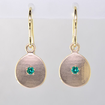 These sweet gemstone earrings shimmer when you wear them. Beautiful in rich 14 Karat yellow gold, these medallions with chatham created emerald gemstones in the center( 2mm), hanging from 14 Karat yellow gold wires.  Earrings measure 3/4 inch long. Available in other colors. Please call for pricing.
Designed and created in our studio by the artist Stuart J.

Chatham Gemstones are also available in Ruby, Sapphire, and Alexandrite.

 

                                                                                                                                                                                                                                                                                                                                                                               Chatham® Created Gemstones are grown in carefully controlled laboratory conditions. They are chemically and optically identical to their natural counterparts, yet cost much less. Because the environment in which they are grown is controlled, the imperfections often found in natural gemstones, are absent in Chatham® Created Gemstones. Because of this, and superior cutting, Chatham® gems exhibit the color and sparkle of the finest natural gems. Each one comes with a Certificate of Authenticity, and a Lifetime Warranty.