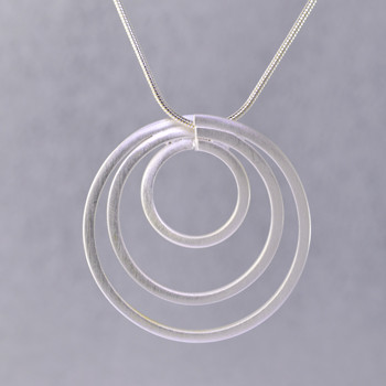 Playful and bright, this circle of love pendant is a delight to wear. Sterling Silver with a swirl pattern and hangs on a 1.2mm Sterling Silver snake chain, 16 inches long. Pendant measures 1 1/4 inches long.

Handmade in Istanbul, Turkey.