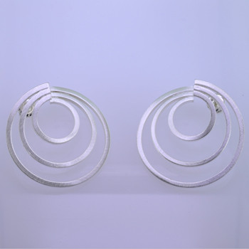 Playful and bright, these circle of love earrings are a delight to wear. Sterling Silver with a swirl pattern and hangs on a post. Earrings measure 1 inch long and 1 1/4 inches wide.

Handmade in Istanbul, Turkey.