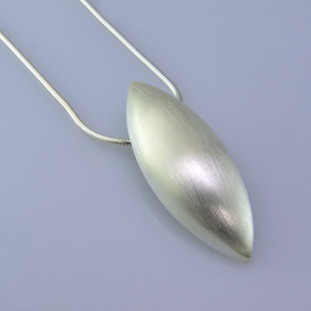 Sleek and modern, this pod pendant is beautiful and elegant.  Easy to wear from day to night. Sterling silver with a smooth finish, and hangs on a 1.2mm Sterling silver snake chain, 16 inches long. Pendant measures 1 inch long.  Made in Istanbul, Turkey.