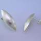 Sleek and modern, these pod earrings are beautiful and elegant.  Easy to wear from day to night. Sterling silver with a smooth finish, and hangs on a post. Earrings measure 1 1/4 inches long.  Made in Istanbul, Turkey.