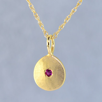 This sweet gemstone pendant shimmers as you wear it. Beautiful in 14 Karat yellow gold, this medallion has a rich deep red ruby gemstone in the center, and hangs on a 1 mm 14 karat yellow gold rope chain,18 inches long.Pendant measures 3/4 inch long. Available in other colors. Please call for pricing.

Designed & Created in our studio by the artist Stuart J.
