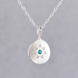 This sweet pendant has a special, hand applied finish that shimmers when you wear it. Beautiful and shiny sterling silver drop, sprinkled with .06 carat total weight of ideal cut diamonds, with a glowing Chatham® created emerald gemstone in the center. Comes with an 18 inch, sterling silver oval cable chain. Pendant measures 5/8 inch long.

Chatham Gemstones are also available in Ruby, Sapphire, and Alexandrite.

Designed and created in our studio by the artist Stuart J.

Chatham® Created Gemstones are grown in carefully controlled laboratory conditions. They are chemically and optically identical to their natural counterparts, yet cost much less. Because the environment in which they are grown is controlled, the imperfections often found in natural gemstones, are absent in Chatham® Created Gemstones. Because of this, and superior cutting, Chatham® gems exhibit the color and sparkle of the finest natural gems. Each one comes with a Certificate of Authenticity, and a Lifetime Warranty.