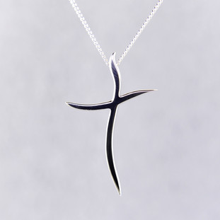 Elegant and modern, curved sterling silver cross pendant hanging from a 0.9mm sterling silver curb chain, 20 inches long. Cross measures 1 1/8 inches long, by 3/4 inches wide.

Designed and created in our studio by the artist Stuart J.