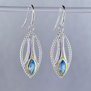 You will be captivated by this mix of modern and vintage in these elegant earrings.  The mix of sterling silver and 18 karat green gold is magical as these earrings comes together. The 18 karat bezels make these beautiful 8x4mm marquise, sea blue color, Swiss blue topaz gemstones pop! The blend of the two metals is sophisticated and fun, all at the same time. Perfect for any time of the day or night. These earrings hang on heavy sterling silver ear wires, and measure 1 1/2 inches long.

Designed and created in our studio by the artist Stuart J.