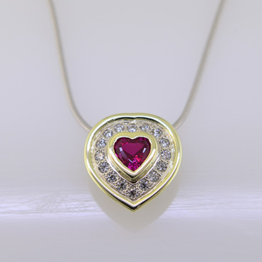 Timeless and elegant ruby and diamond halo heart pendant with a sophisticated flare. Custom designed with .23ct. of pave' set ideal cut diamonds, makes this pendant sparkle like crazy. A beautiful .55ct. created heart shaped ruby is the focal point of this diamond pave' halo. This diamond pendant is set in a 14karat green gold bezel to accentuate it's color. Not a single prong to worry about. The diamond pendant is made in 14 karat white gold, with a 14 karat green gold accent border around the diamonds. You will love  the custom touches of this sweet pendant, like the beautiful open design on the underside. Measures 1/2 long. Hangs on a .09mm 14 karat white gold snake chain 20".

As with all our designs, we will make this any way you like, with any gemstones you like.

Custom designed and handcrafted in our studio by the artist Stuart J.