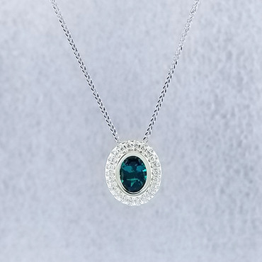 We created this timeless Chatham Created Emerald and diamond halo pendant with a modern flare. There are no prongs to worry about, and our special setting style makes the .17carat of super sparkly, Ideal cut diamonds look like twice the amount. Handmade in 14 karat Green gold, one 1.14 carat oval, bezel set, deep green emerald create enough drama for evening, but not too much for every day wear. Hanging on a .07mm Wheat Chain 18" White Gold, it measures about 1/2" long, and is designed and handcrafted by the artist, Stuart J. 

Call us for more information about how we can customize this design Just For You.