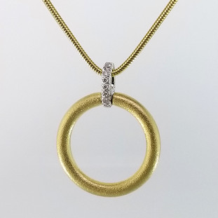Inspired by natural colors and shapes, this sophisticated diamond circle pendant is crafted in rich 18 karat yellow gold, with a 18 karat white gold top, set with .07ct ct. total weight of sparkling diamonds. Hanging on an 18 karat yellow gold, 1.6mm snake chain 18", This pendant is truly a knock out piece. Exceptional in every way, and designed by the acclaimed jeweler Aaron Henry, in his California studio.