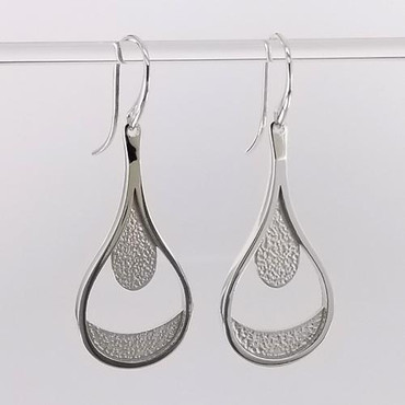Custom designed Teardrop dangle earrings created in silver, with a beautiful detailed finish.  Hangs on silver wires.  These earrings measure 1 3/4 inches. Crafted in our studio by master artist Stuart J.
