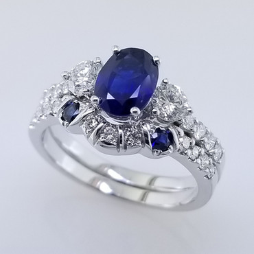 Wed- 399-  We custom designed this wedding band to go with our customers engagement ring.  Created in white gold, setting 2- matching round sapphires, and many sparkly diamonds to make this wedding set complete.