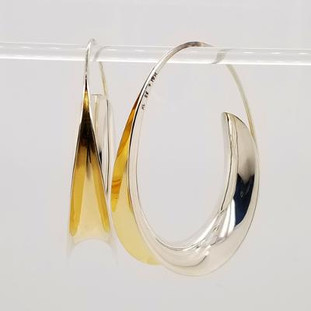 Jewelry to soothe and flow, our Zen earrings are the perfect oval hoop earring with a twist. Hand-forged silver and 18 karat yellow gold. Elegant, casual, and comfortable with a modern flare. These amazing hoop earrings stand 1 1/8 inches tall.  