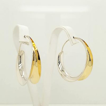 Jewelry to soothe and flow, our Emery earrings are the perfect round hoop earring with a twist. Hand-forged silver and 18 karat yellow gold. Elegant, casual, and comfortable with a modern flare. These amazing hoop earrings stand 1 1/2 inches tall.  