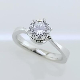 This solitaire diamond engagement ring is timeless, but with a modern twist. Shown in 14 karat white gold, with a 1ct. round diamond (sold separately), this ring will set off that sparkly diamond beautifully.
We can make this in any color of gold, or platinum, and with any size diamond, ours or yours.
Designed, and created in our studio by the artist, Stuart J.