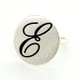 Cherish is our modern take on the timeless initial ring. It signifies how important you are, and symbolizes your name. With our modern round top, and our beautiful scripted initial, etched in black, you will surely be noticed wearing this. Shown here in sterling silver, set with our super sparkly .03ct. lab grown diamond. Measures 3/4 inch wide. This initial ring is also available in 14 karat yellow, white, or rose gold, and is available with all the birthstone colors.

Designed and created in our studio, by the artist Stuart J.