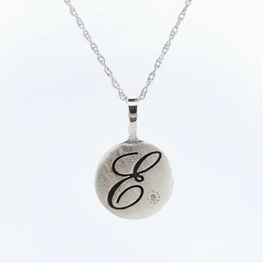Cherish is our modern take on the timeless initial pendant. It signifies how important you are, and symbolizes your name. With our modern round shape, and our beautiful scripted initial etched in black, you will surely be noticed wearing this. Created in silver, set with our super sparkly .02ct. lab grown diamond, it includes a 16 inches long sterling silver rope chain, and measures 5/8 inch in diameter. This initial pendant is also available as a charm, and can be made in 14 karat yellow, white, or rose gold, and is available with all the birthstone colors.

Designed and created in our studio, by the artist Stuart J.