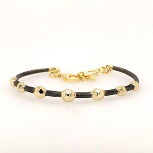 Our beautiful Celestial bracelet with its  yellow gold plated balls, sits on a ruthenium bracelet. Born in Spain, this bracelet feels a little bit edgy, but loads of fun! Measures 1/4" wide, and enlarges for most every wrist size.