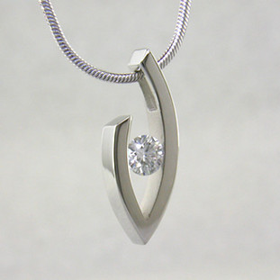 Simple elegance describes this pendant, which shows off a single Diamond to perfection. We can make this piece for any size Diamond and in most shapes - including marquise, pear and oval. Crafted in 14 karat White Gold, this one measures about 1 inch and holds a 0.81ct. F color, VS-2 clarity Diamond, elegantly displayed on a 14 karat White Gold 1.5mm round omega wire necklace, 16 inches long.

Got an extra diamond sitting in a drawer? We know what to do with it.

Please allow 2-3 weeks for delivery.

Designed, and created in our studio by the artist Stuart J.
