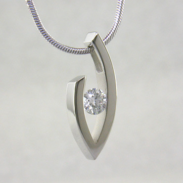 Simple elegance describes this pendant, which shows off a single Diamond to perfection. We can make this piece for any size Diamond and in most shapes - including marquise, pear and oval. Crafted in 14 karat White Gold, this one measures about 1 inch and holds a 0.81ct. F color, VS-2 clarity Diamond, elegantly displayed on a 14 karat White Gold 1.5mm round omega wire necklace, 16 inches long.

Got an extra diamond sitting in a drawer? We know what to do with it.

Please allow 2-3 weeks for delivery.

Designed, and created in our studio by the artist Stuart J.