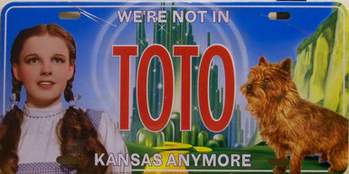 EMBOSSED METAL WIZARD OF OZ LICENSE PLATE (DORTHY & TOTO)  WITH SLOTS FOR EASY MOUNTING MEASURES 12" X 6"     "WE'RE NOT IN KANSAS ANYMORE"