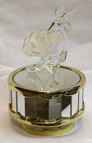 GLASS HUMMING BIRD OVER FROSTED FLOWER CAROUSEL 
22K GOLD TRIM PLAYS OVER THE RAINBOW 4" X 4" X 6" 
HAND CRAFTED & HAND PAINTED
