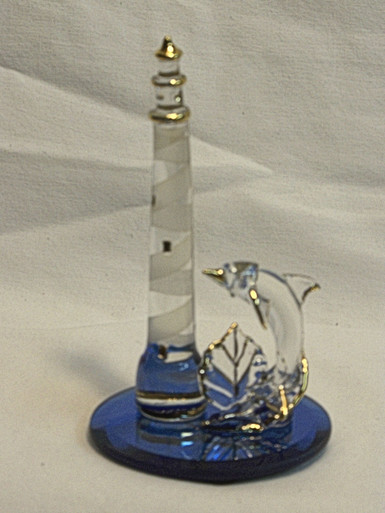 GLASS LIGHTHOUSE WITH DOLPHIN ON BLUE MIRROR
 22K GOLD TRIM 2 1/2" X 2 1/2" X 4 1/4" 
HAND CRAFTED & HAND PAINTED