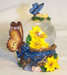 MINITURE SNOW GLOBE WITH BUTTERFLYS & YELLOW FLOWERS MEASURES 2 1/2" X 2" X 2 1/2"