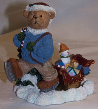 BEAR CUB ON ICE SKATES PULLING SLEIGH WITH TOYS 
MEASURES 5 1/4" X 3 1/4" X 4 3/4"