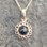 Small 9ct gold and Whitby Jet daisy necklace on gold curb chain