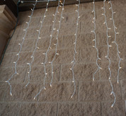 These white corded curtain lights have 200 incandescent mini lights built in. The curtain lights have eight foot drops and can connect up to two sets. The strands are six feet wide. 